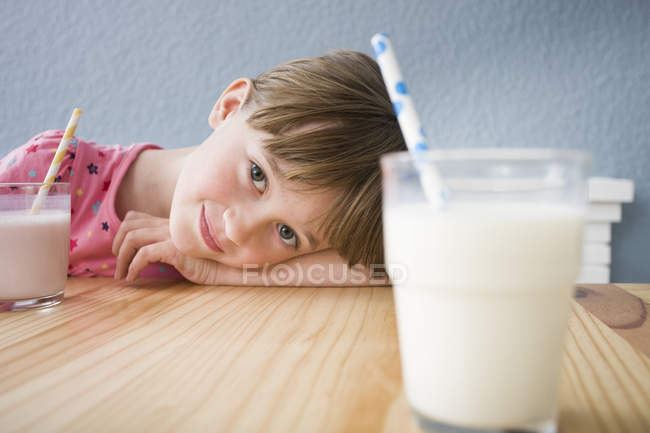 Menina olhando para o copo de leite — Fotografia de Stock