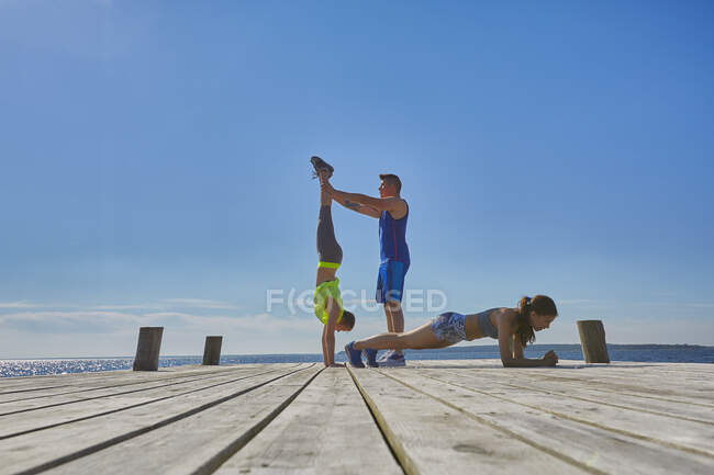 Freunde am Pier machen Handstand und Liegestütze — Stockfoto