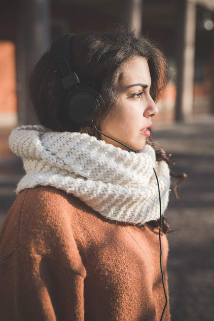 Портрет молодої жінки в навушниках у парку — стокове фото