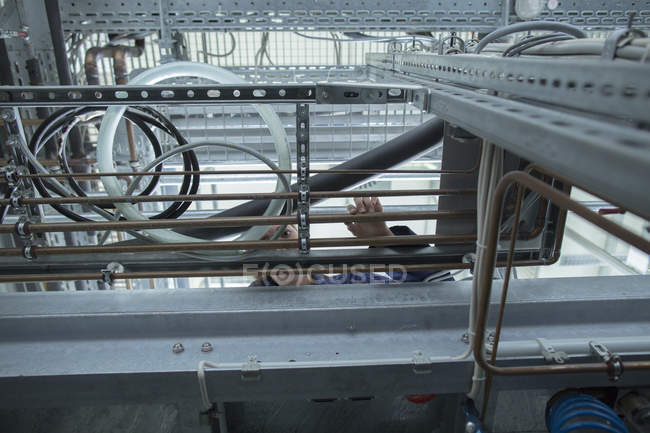 Niedrigwinkel-Ansicht einer Ingenieurin bei der Untersuchung industrieller Rohrleitungen in einer Fabrik — Stockfoto