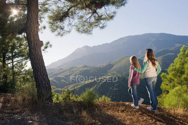 Mother & daughter overlooking mountains — Stock Photo