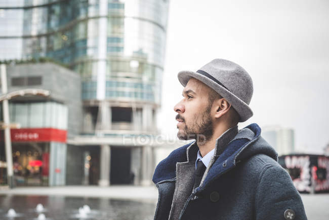 Side view of man in hat walking in city — Stock Photo