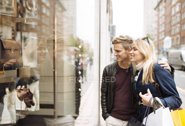 Casal jovem janela de compras, Londres, Inglaterra, Reino Unido — Fotografia de Stock