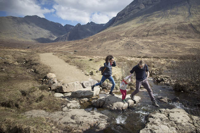 Family crossing stream, Fairy Pools, Isola di Skye, Ebridi, Scozia — Foto stock