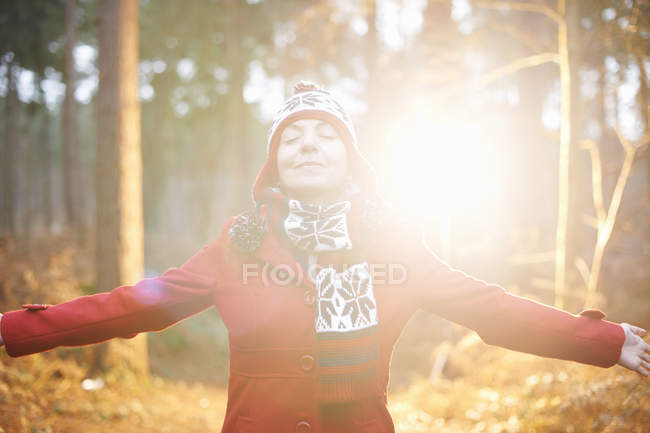 Mature woman in hat and coat with arms out — Stock Photo