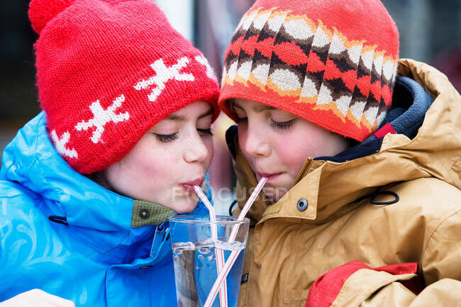 Duas crianças bebendo copo de água — Fotografia de Stock