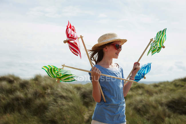 Girl in sand dunes with windmills — Stock Photo