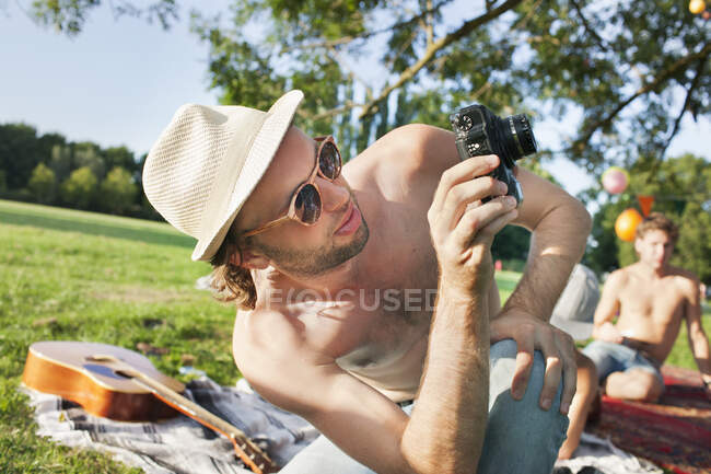 Молодий чоловік фотографує на вечірці парку — стокове фото