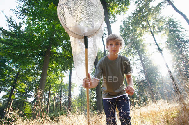Портрет мальчика с сеткой для бабочек на улице — стоковое фото