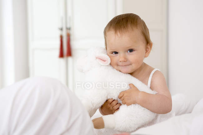 Menina bebê segurando brinquedo macio — Fotografia de Stock