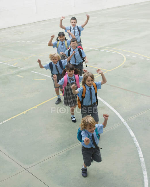 Niños de la escuela corriendo en el patio - foto de stock