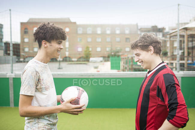 Due giovani uomini che giocano a calcio sul campo di calcio urbano — Foto stock