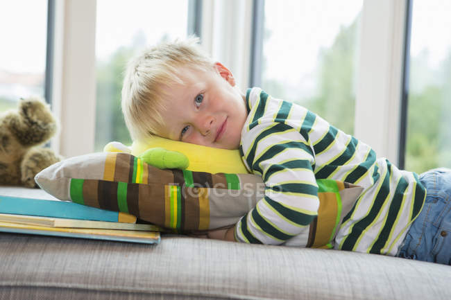 Portrait of tired boy lying on sofa — Stock Photo