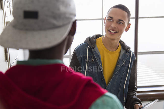 Студенты-мужчины разговаривают возле шкафчиков — стоковое фото