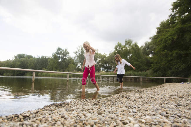 Dos chicas remando en el lago rural - foto de stock