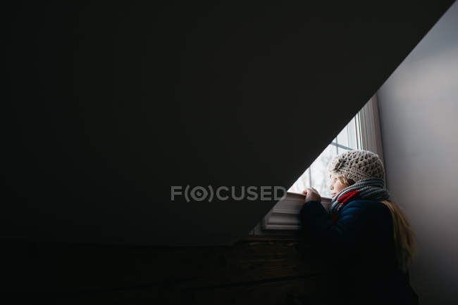 Girl looking out of window — Stock Photo