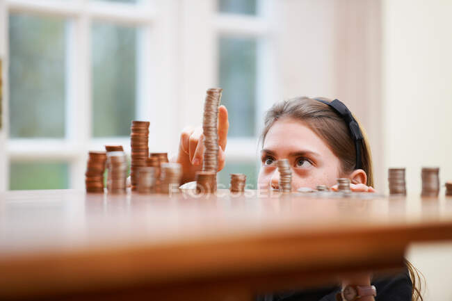 Girl counting piles of money — Stock Photo