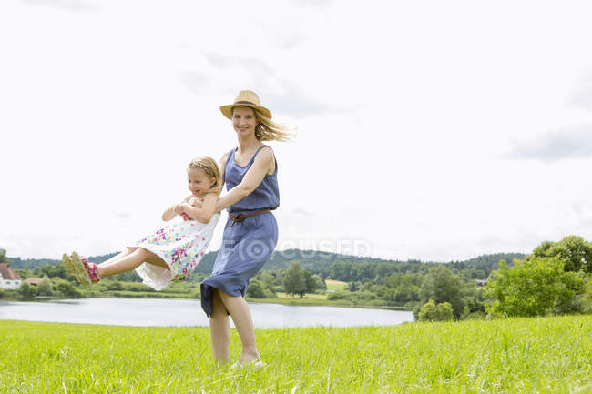Мать поднимает дочь в поле — стоковое фото