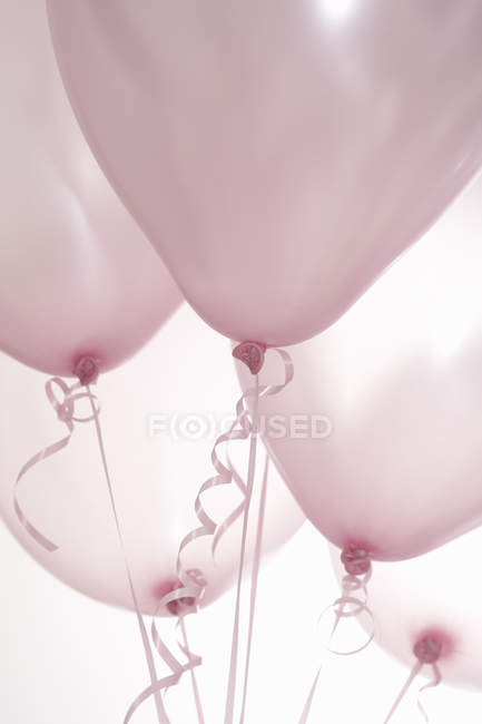 Cinco globos rosados en cintas - foto de stock