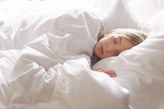 Rubia chica de pelo dormido en la cama - foto de stock