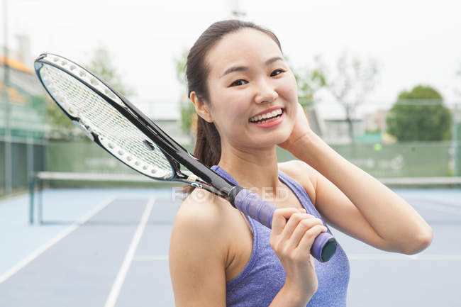 Portrait of young female tennis player on tennis court — Stock Photo