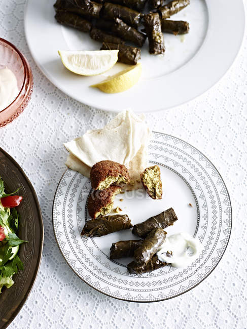 Still life with plate of slow cooked lamb in vine leaves — Stock Photo