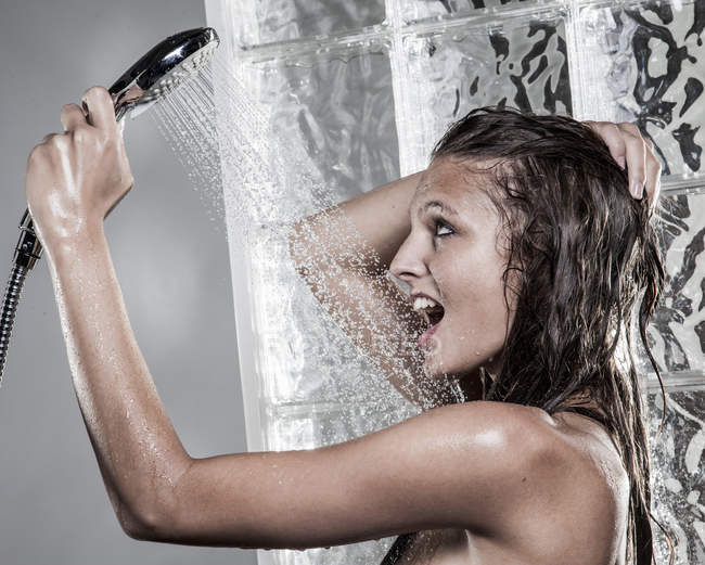 Donna con bocca aperta e capelli bagnati fare la doccia — Foto stock