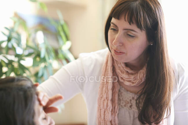 Female make up artist applying foundation to clients forehead — Stock Photo