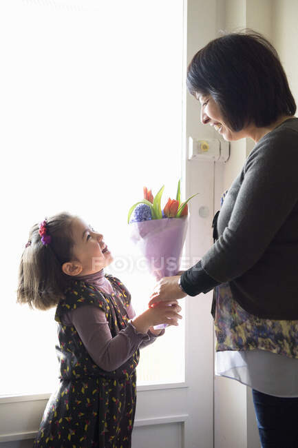 Молода дівчина дарує мамі квіти — стокове фото