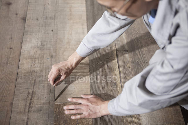 Charpentier vérifiant la qualité de la planche en bois dans l'usine, Jiangsu, Chine — Photo de stock