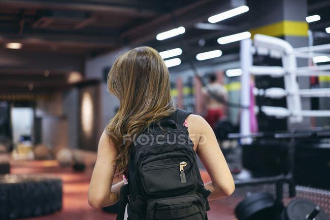 Вид ззаду молодої жінки, що носить рюкзак, який готується до тренажерного залу — стокове фото