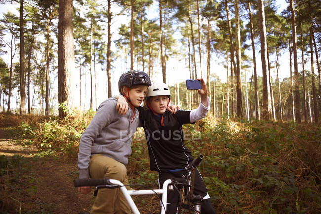 Hermanos gemelos en bicicletas BMX tomando autorretrato - foto de stock