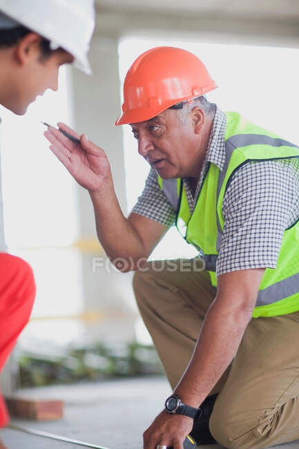 Vieux travailleur parlant à un jeune travailleur — Photo de stock
