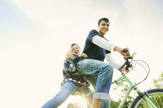 Retrato de baixo ângulo de jovem casal na bicicleta — Fotografia de Stock