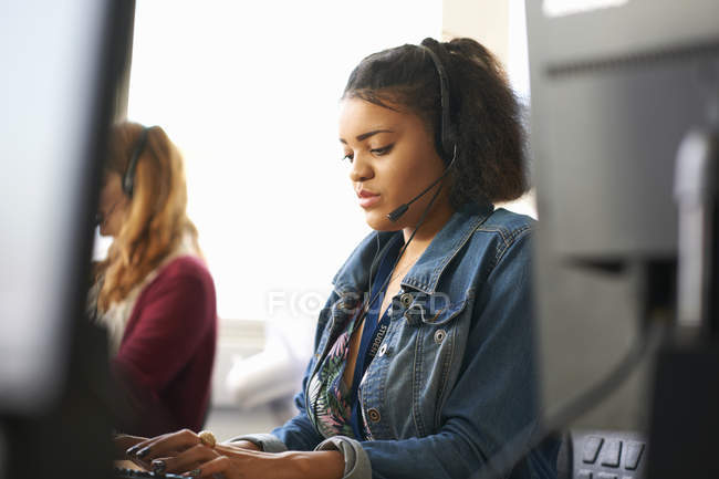 Estudantes do sexo feminino digitando no computador desktop em sala de aula — Fotografia de Stock