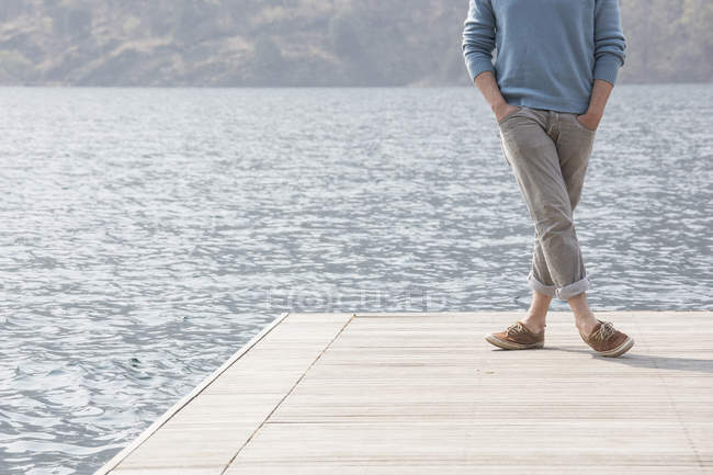 Обрезанный вид молодого человека, стоящего на пирсе, озеро Мергоццо, Вербания, Пьемонте, Италия — стоковое фото