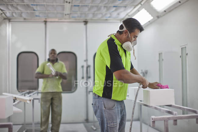 Man spraying box in carpenters workshop — Stock Photo