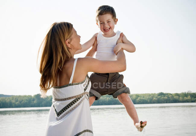 Madre sollevamento bambino in aria — Foto stock