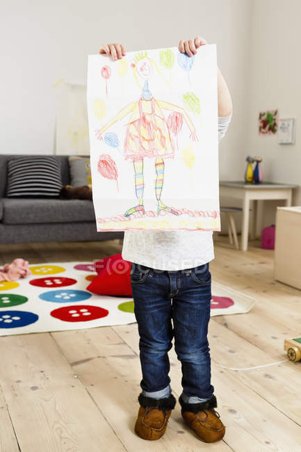 Toddler holding up painting in living room — Stock Photo