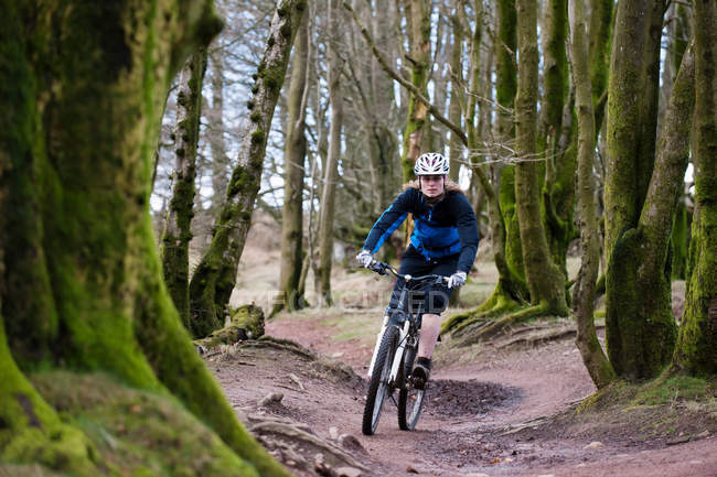 Bicicleta de montaña mujer en bosques - foto de stock