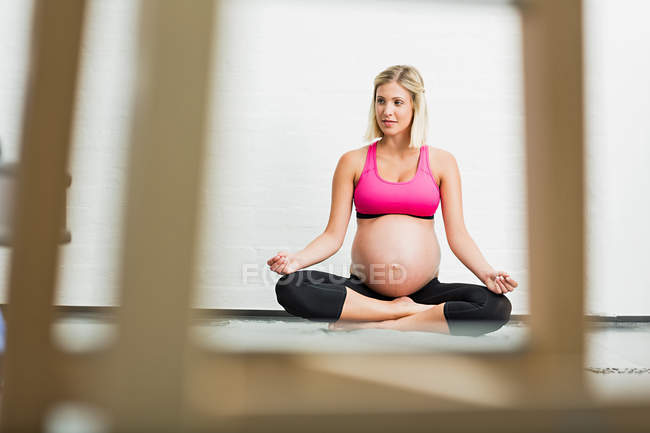 Embarazo a término mujer joven practicando yoga - foto de stock