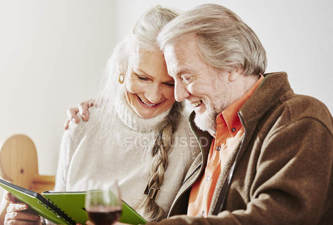 Seniorenpaar schaut sich Buch an — Stockfoto