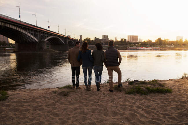 Cuatro amigos por río, Varsovia, Polonia - foto de stock