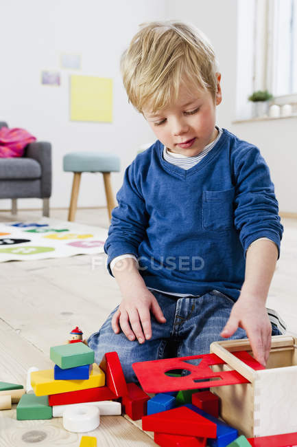 Хлопчик грає з будівельними блоками вдома — стокове фото