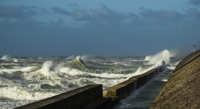 Stürmische Meereswellen bespritzen Hafenmauer — Stockfoto