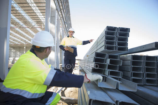 Строитель и менеджер участка проверяет балки на строительной площадке — стоковое фото