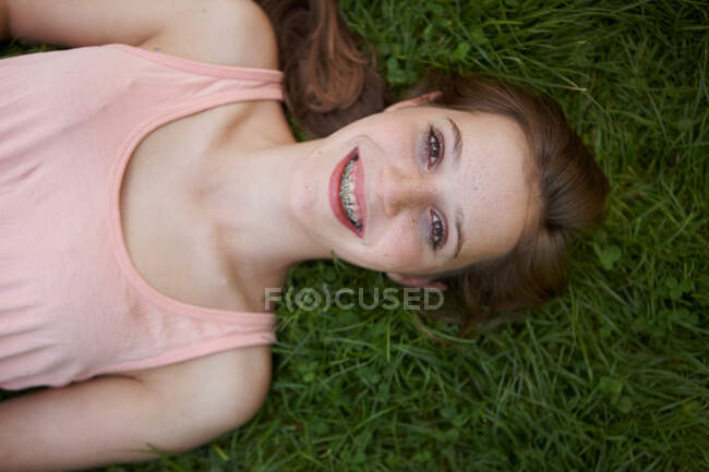 Chica joven tendida en la hierba en un parque - foto de stock