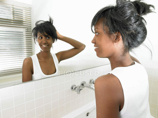 Mulher no banheiro, olhando no espelho — Fotografia de Stock