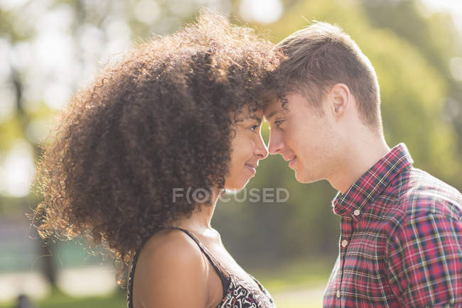 Молодая пара, стоящая лицом к лицу в парке — стоковое фото