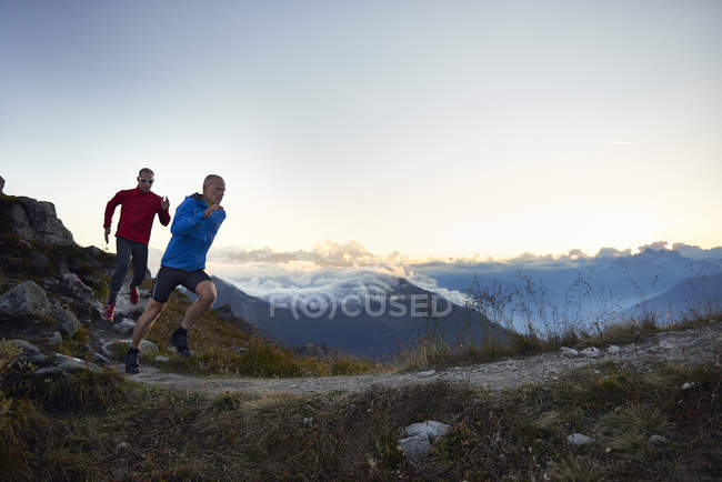 Двое взрослых мужчин бегут по тропе, Вале, Швейцария — стоковое фото